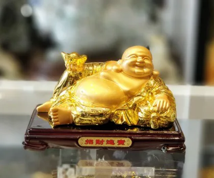 Phật di lạc vàng bóng tay cầm nén vàng nằm trên túi tài lộc vàng đế gỗ - Tài Nguyên Cuồn Cuộn LN190